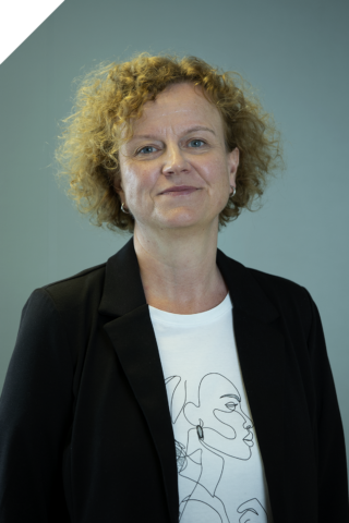 Portrettfoto av regnskapskonsulent Christine Kjelkenes med lyse krøller og svart bleser